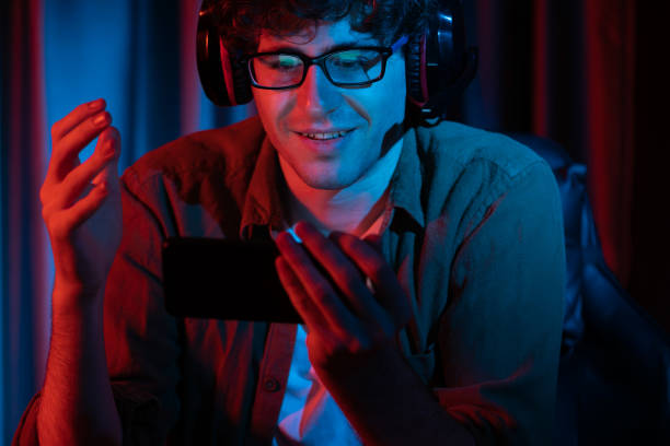 istock Smiling streamer team playing with Esport online on smartphone. Gusher. 1979661620