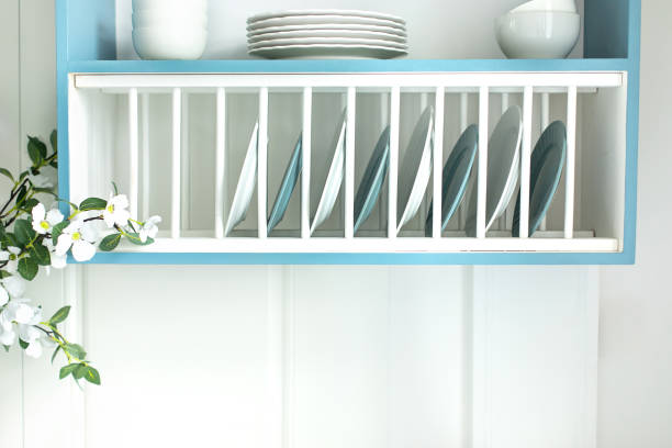 istock Eco friendly wooden drying rack. Open cabinet with different clean plates and bowls in kitchen. Open shelves in the cuisine. Stand for utensils in the kitchen. Shelf for tableware drying. 1979664271