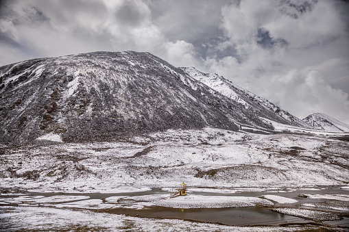 A temple in the middle of Snow covered peaks at KhardungLa pass, greater Himalayas, en route Leh, Ladakh