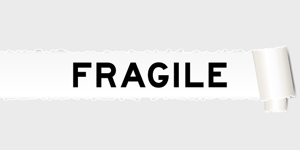 Ripped gray paper background that have word fragile under torn part