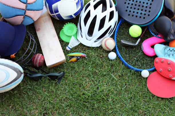 A collection of different sport equipment on grass, with copy space