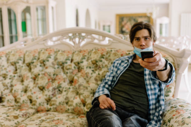 istock back of man watching tv on a sofa on quarantine 1979732449