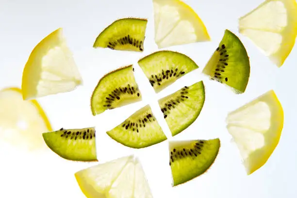 Fruit lemon and kiwi sliced into slices on white background.