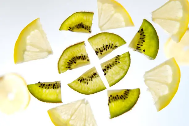 Fruit lemon and kiwi sliced into slices on white background.