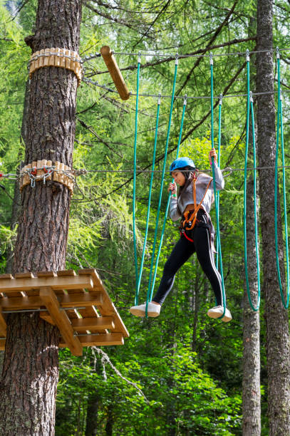 istock Active girl walking on suspended ropes in forest 1979740453
