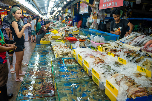 Phuket, Thailand - December 19, 2023: Trade in seafood at the market in Rawai, tourists buy seafood at the seafood market. High quality photo