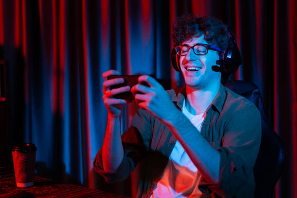 istock Smiling streamer team playing with Esport online on smartphone. Gusher. 1979746770