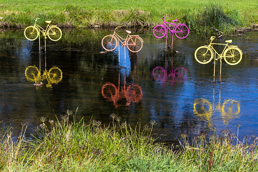 Installation of colorful bicycles in water on a sunny summer day