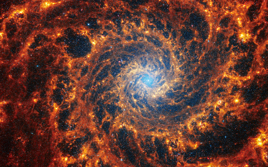 Face-on spiral galaxy, NGC 628. Bright orange and red galactic long-range captured imagery. Elements of this image furnished by NASA (observed by the Webb telescope)