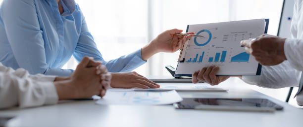 istock Business team together making investment plan at meeting pointing at graph and chart analyzing company financial report. 1979786592
