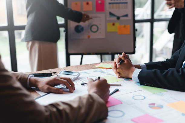 istock Group of businesspeople meeting and presenting, discussing and analyzing data, pointing to charts and graphs of finance and accounting, business ideas for future growth. 1979806999
