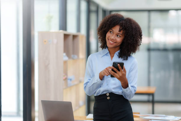 istock Smiling businesswoman using smartphone at office. 1979808068
