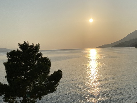 Orange sun reflect their rays in Adriatic sea visible mountains