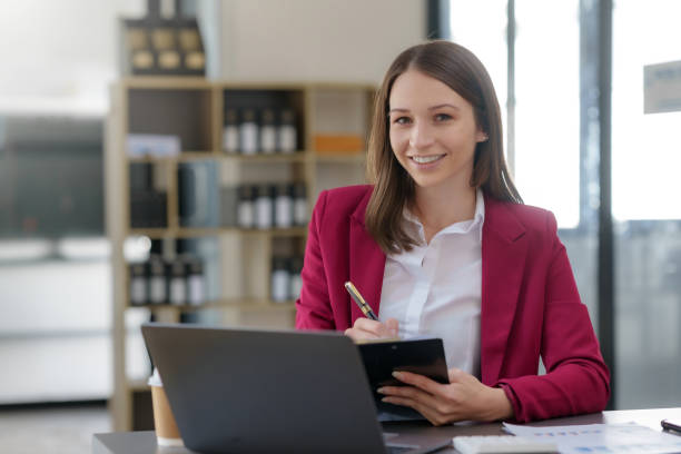 istock Happy businesswoman taking notes with laptop and document in office. 1979814458