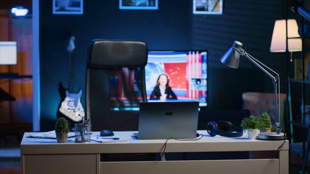 istock Home office desk in front of smart TV displaying news program broadcasting 1979882714
