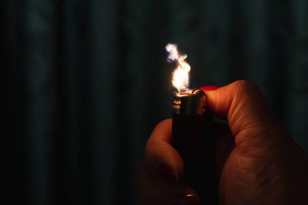 Sparks coming from lighter over black background.Womans hand,Flame and sparks coming from lighter.Selective focus.Copy space.