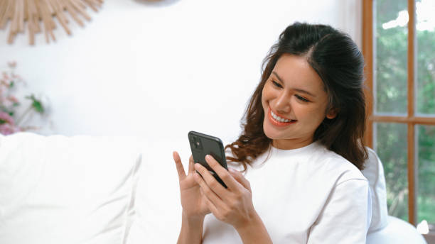 istock Young woman using smartphone browsing for online shopping E commerce by online payment gateway at vivancy home. Modern and convenience online purchasing make secure and convenient purchases. 1979898224
