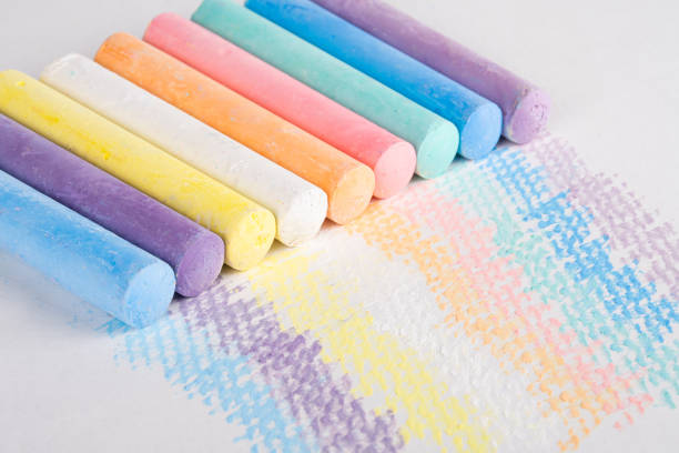 Multicolored chalk for drawing. Bright color of dry pastel on a white surface. Smooth stroke line drawing. Stain drawn on paper