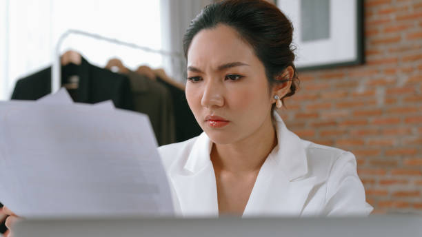 istock Young businesswoman sitting on the workspace desk using laptop computer for internet online content writing or remote working from home. Clothing and textile business marketing analysis. Vivancy 1979928399