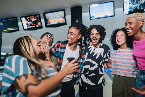istock Friends using the mobile phone at a bowling club 1979949327