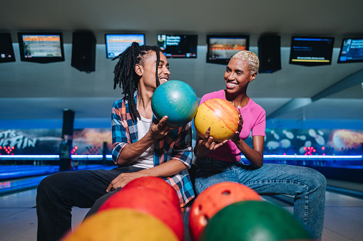 Friends holding bowling balls at a bowling club