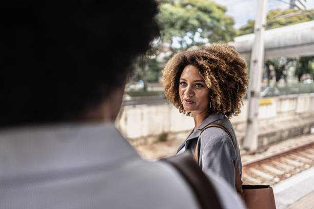 istock Businesswoman talking to someone while waiting for the train on the platform 1979967113