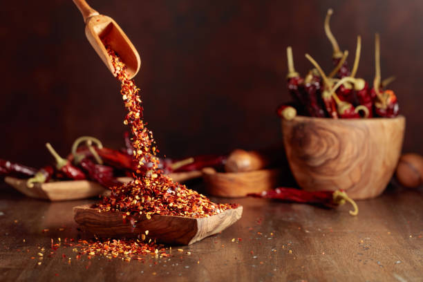 istock Chilli flakes are poured into a wooden dish. 1979990586