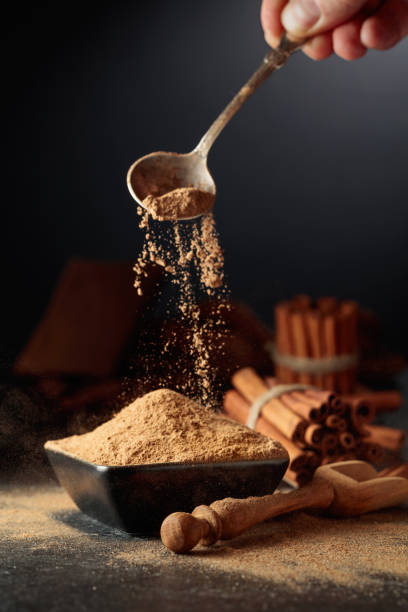 istock Cinnamon powder is poured into a black bowl. 1979991092