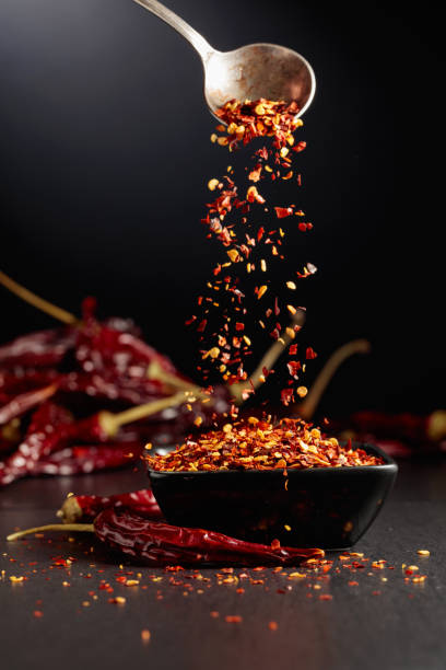 istock Chilli flakes are poured into a black dish. 1979991098