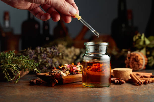 istock Dropping essential herbal tincture into a small glass bottle. 1979991102