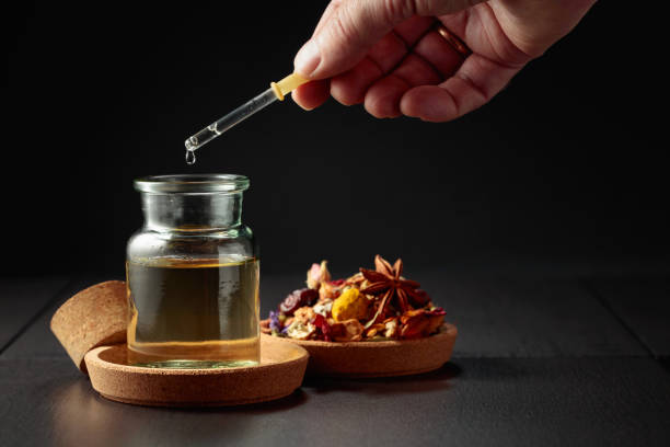 istock Dropping essential oil or herbal tincture into a small bottle. 1979991108
