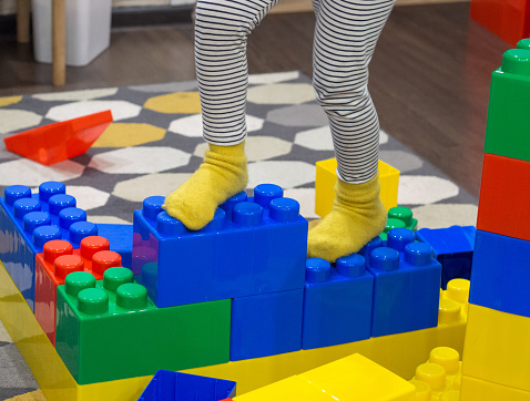 girl plays with drawn blocks of a constructor at home, A child's hand puts large colorful blocks from a children's model set