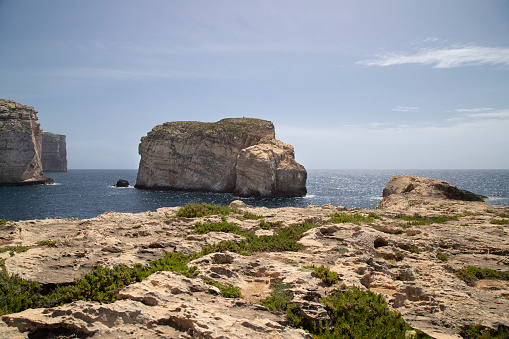 Coastal Cliffs in round bay with dark blue water in gozo, malta.