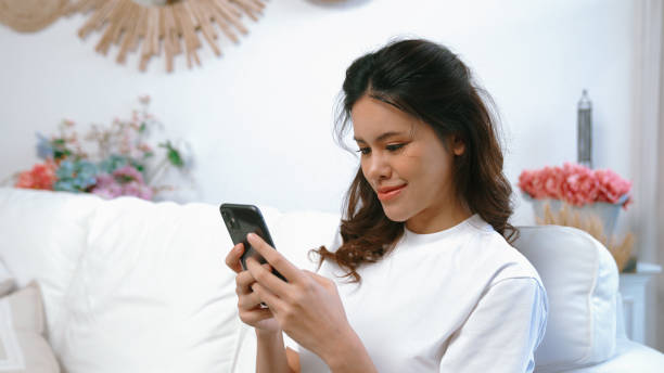 istock Young woman using smartphone browsing for online shopping E commerce by online payment gateway at vivancy home. Modern and convenience online purchasing make secure and convenient purchases. 1980009824