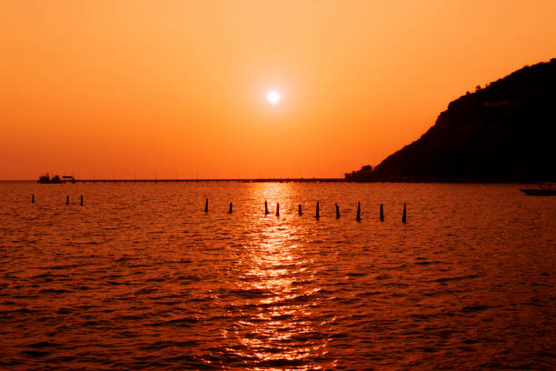 Golden sun setting over calm tranquil ocean in California