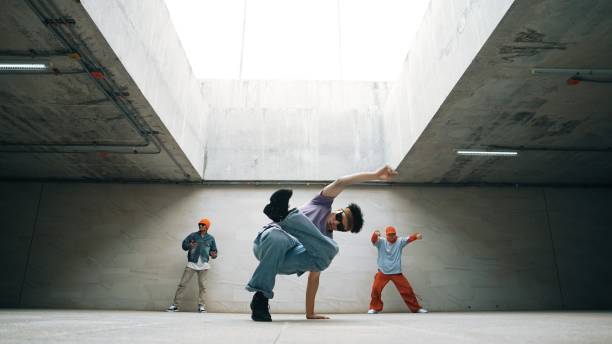 Group of stylish hipster group perform dancing together in building. Sprightly.