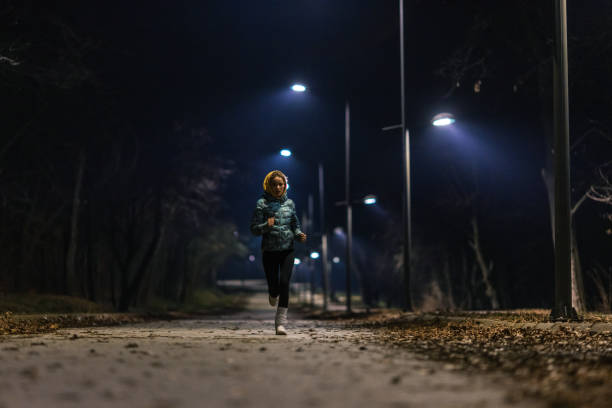 Young woman jogging in park at night