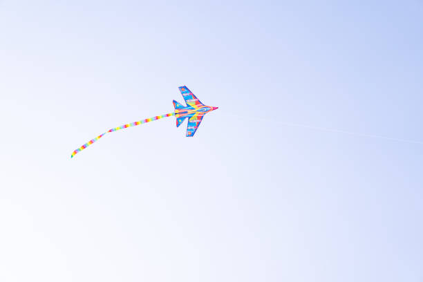 A color kite flying against a blue sky. Kite flying in the sky among the clouds