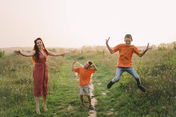 Happy mother having fun with her two sons outdoors. Concept of family and love. Concept of mother's day, relationship with teenagers, care and love.