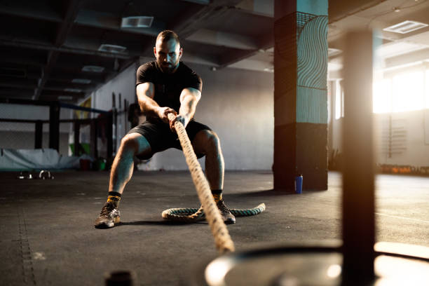 istock In the gym, strong male athlete pulling weights with rope 1980086771