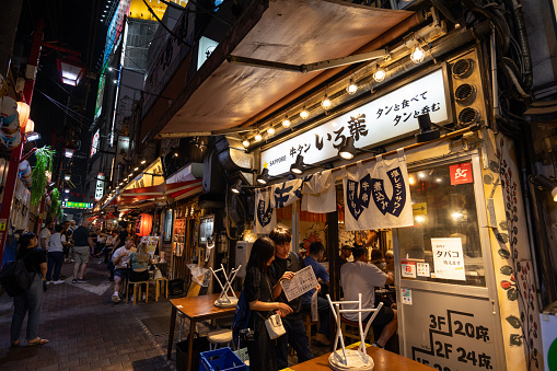 Tokyo, Japan - September 20, 2023 : People at the Omoide Yokocho in Shinjuku, Tokyo, Japan. Omoide Yokocho is a narrow street packed with many Japanese restaurants and bars.