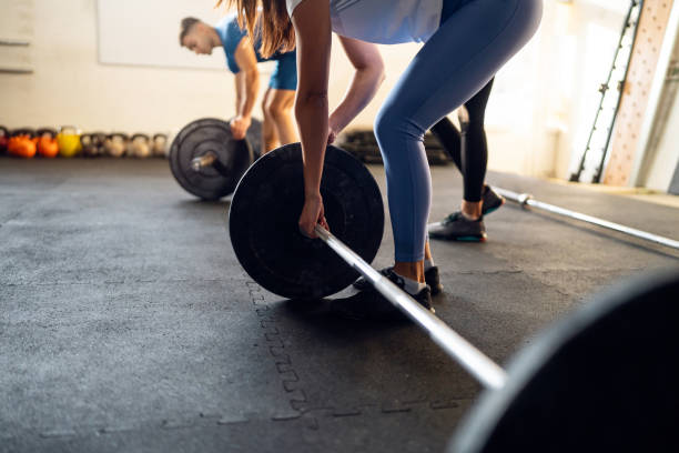 istock People adjusting weights on a barbell, during an group workout at the gym 1980106753