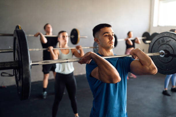 istock Group of people exercise with barbells, at the modern gym 1980117610