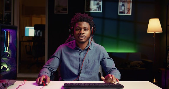 Cheerful gamer feeling excited after finally defeating all enemies while playing on computer. Joyful african american man congratulating himself after winning videogame on gaming PC