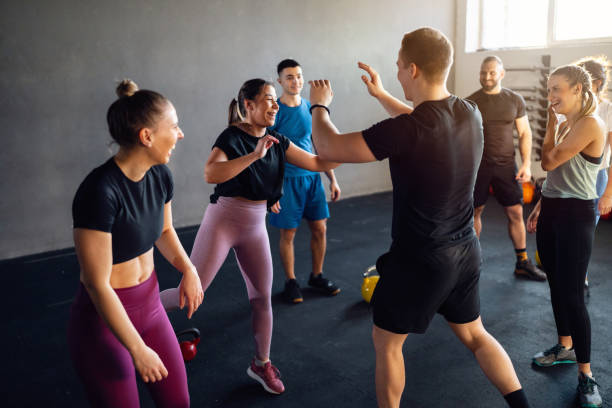 istock Group of people interchange high-five with an cross trainer after an exercise 1980130329