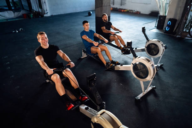 istock Male athletes exercise on a rowing machine at the gym 1980130889