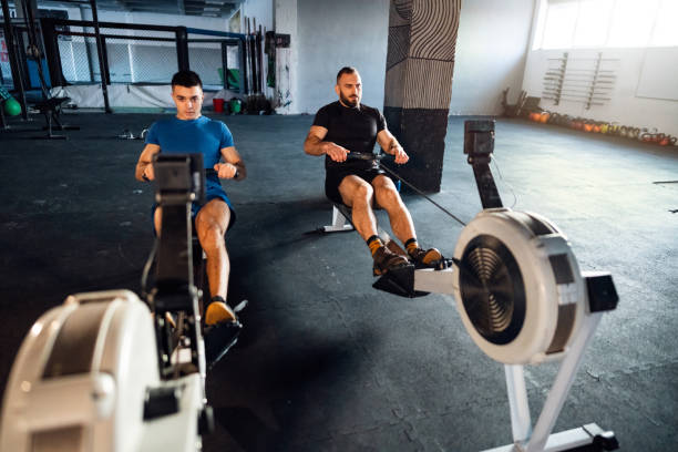 istock Male athletes exercise on a rowing machine at the gym 1980135691