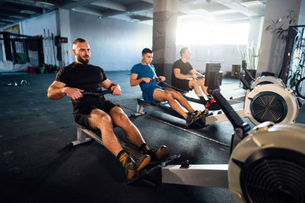 istock Male athletes exercise on a rowing machine at the gym 1980135693