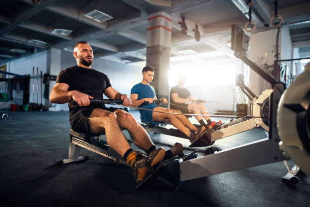 istock Male athletes exercise on a rowing machine at the gym 1980135694