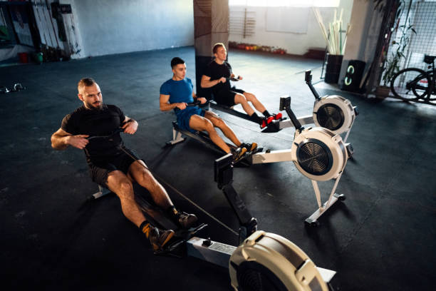 istock Male athletes exercise on a rowing machine at the gym 1980136726
